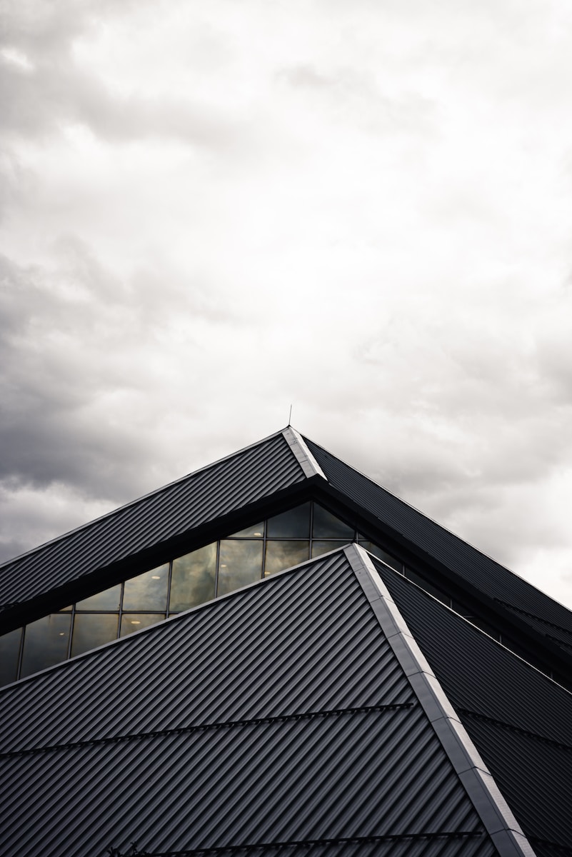 gray and black building under white clouds