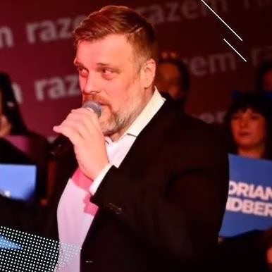 Adrian Zandberg w trakcie rozmowy, podkreślający jego zaangażowanie i dostępność.