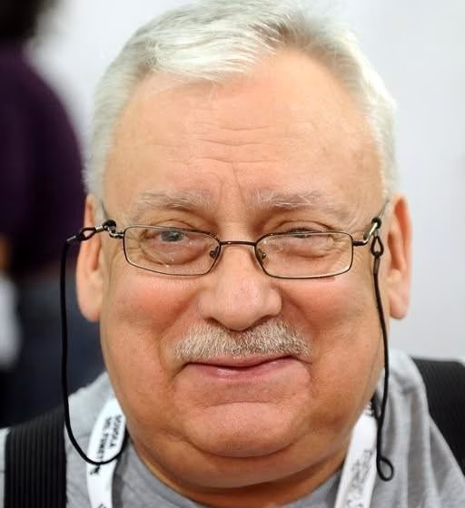 Andrzej Sapkowski w swoim gabinecie, otoczony elementami nawiązującymi do świata Wiedźmina.