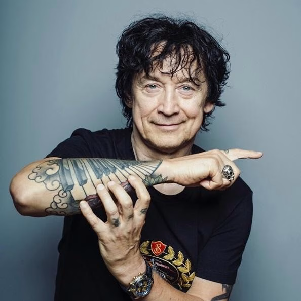 Dłonie Jana Borysewicza grające na gitarze elektrycznej w zbliżeniu.