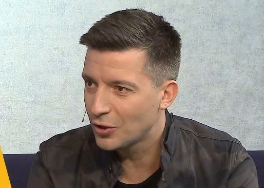 Michał Cessanis podczas podróży, w dynamicznej pozie na tle egzotycznego krajobrazu.