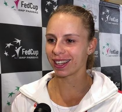 Magda Linette wykonująca silny forhend podczas meczu tenisowego.