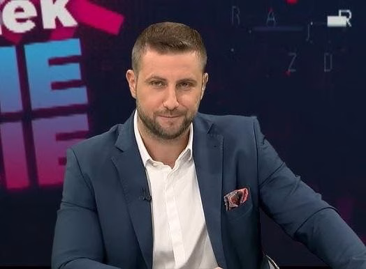 Miłosz Kłeczek podczas pracy w studiu telewizyjnym, prowadzący program.